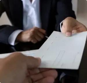 closeup of someone handing an envelope to someone else