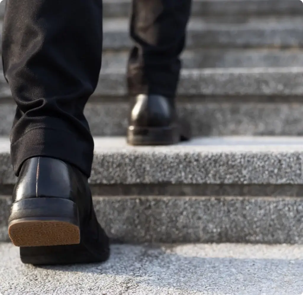 closeup of someones shoes walking up concrete stairs