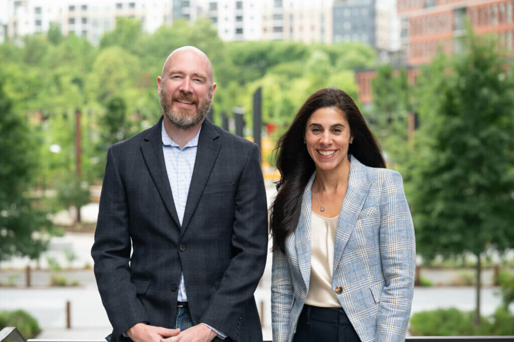 A man and woman outside smiling at the camera